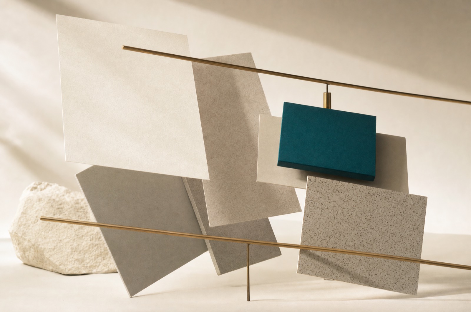 Matte payment cards suspended at angles above a warm off-white surface